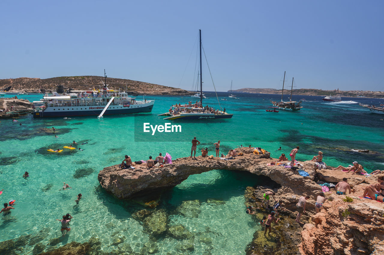 SAILBOATS MOORED ON SEA AGAINST SKY