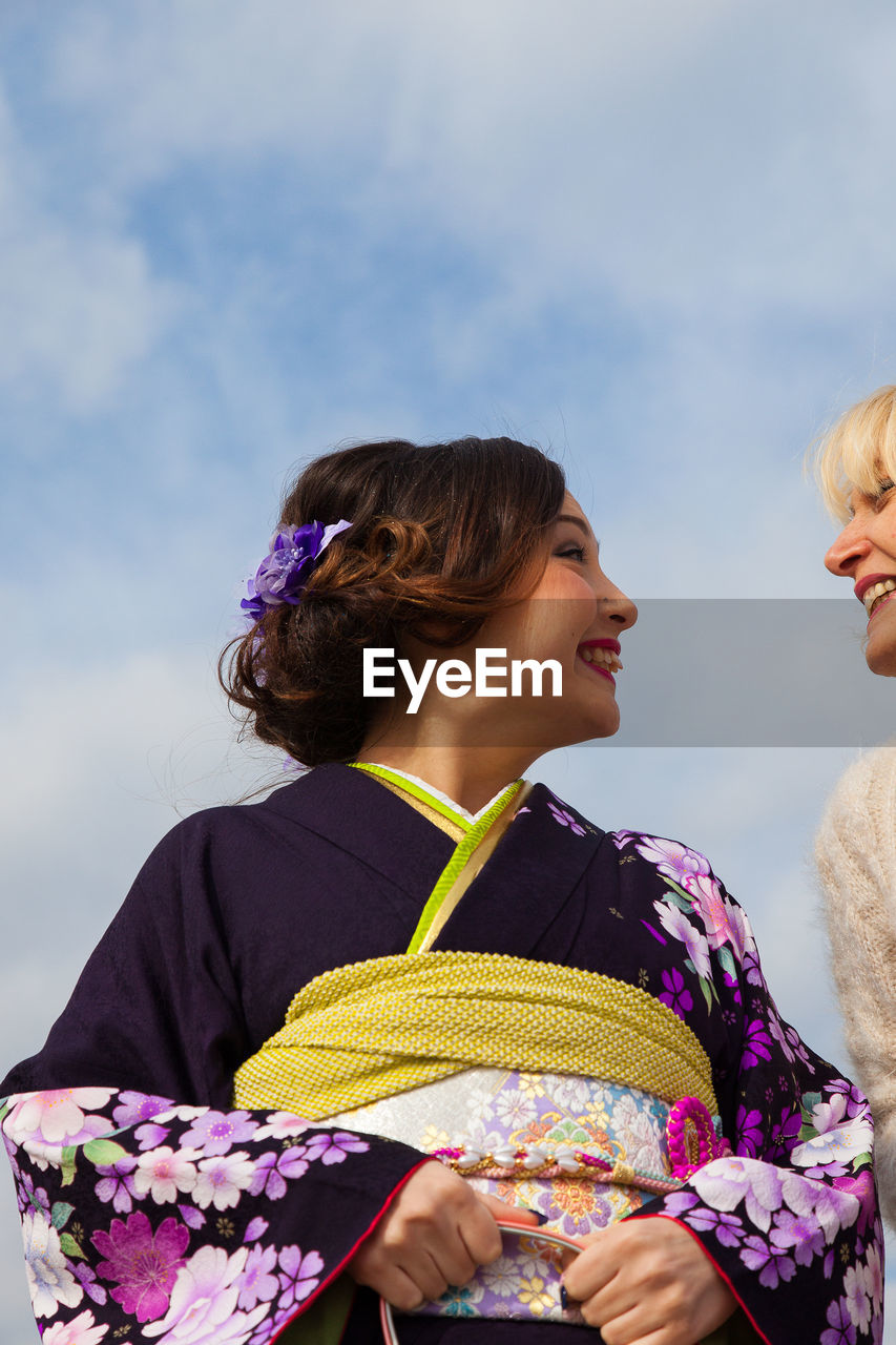 Low angle view of women against sky