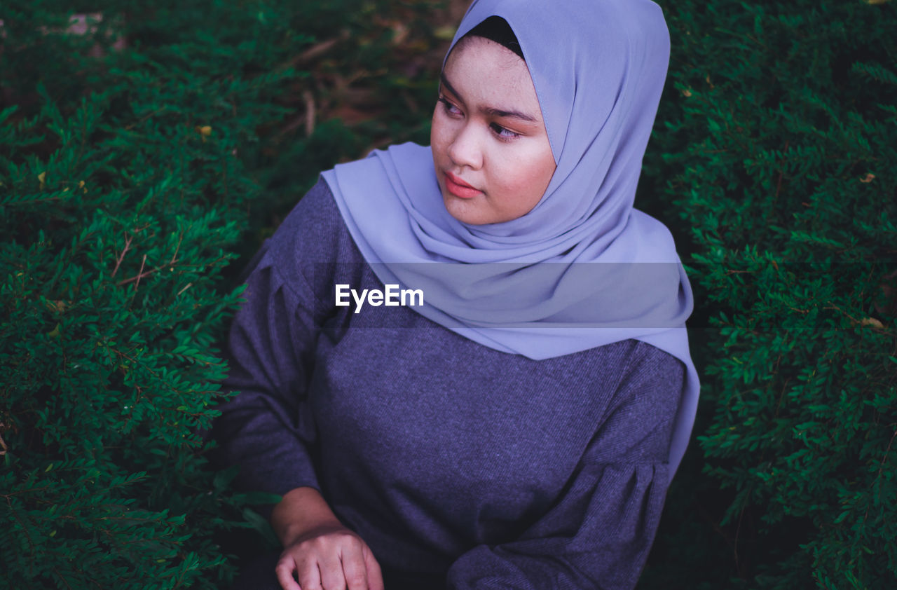 High angle view of young woman in hijab standing on field