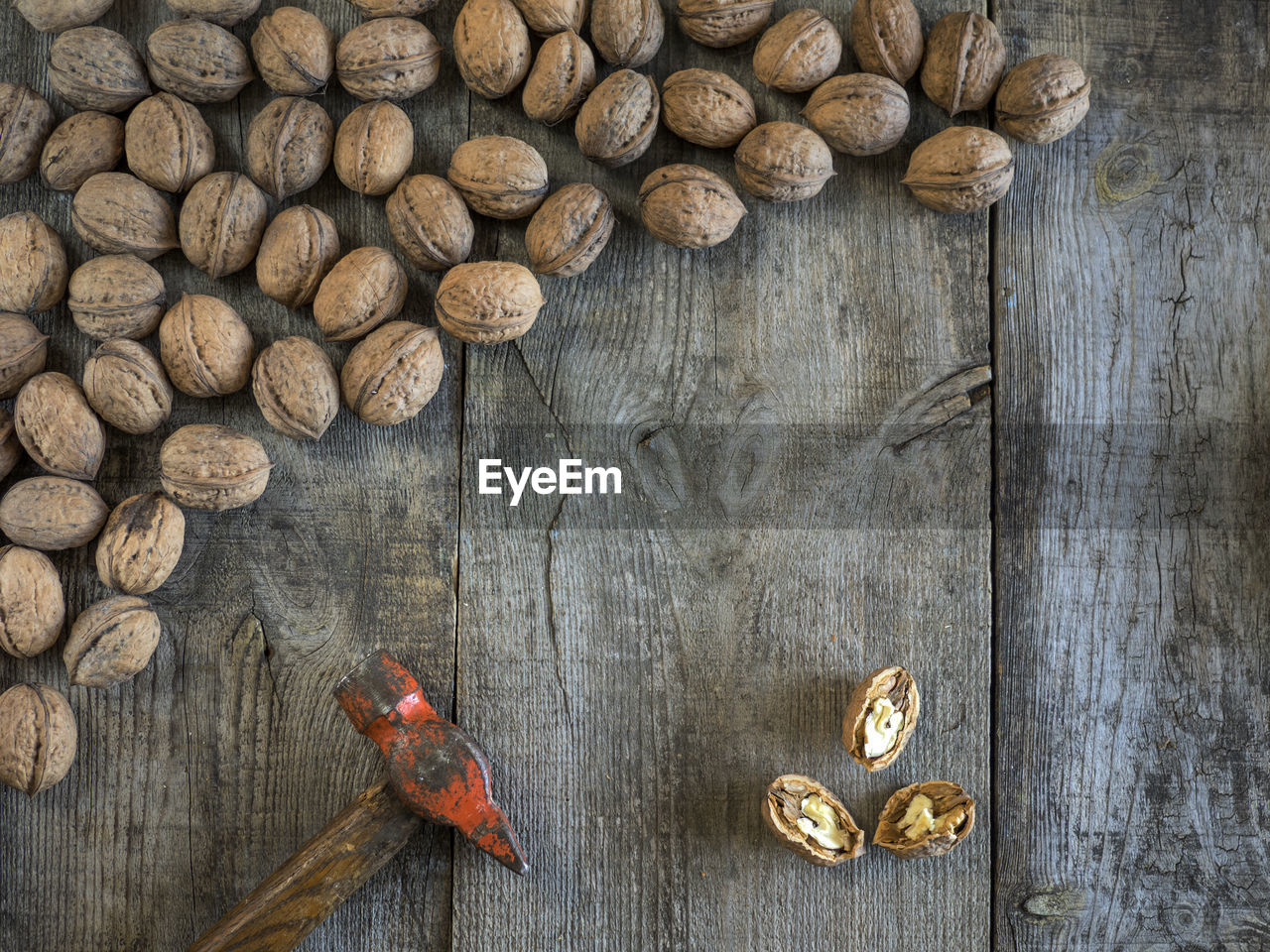 High angle view of walnuts with hammer on table
