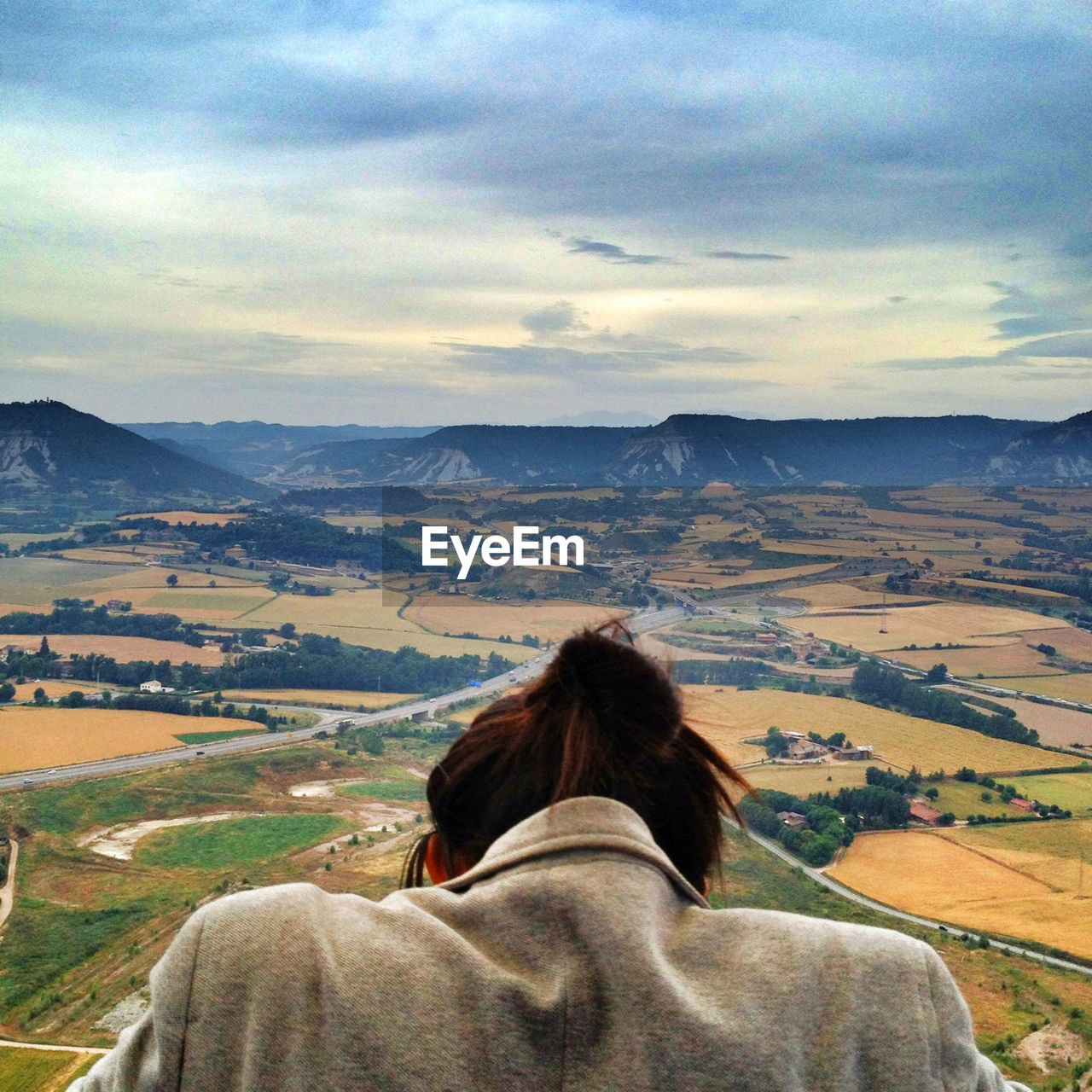 Rear view of woman with rural landscape in background