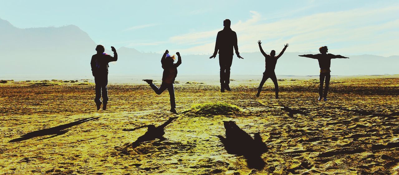 People in mid-air above field