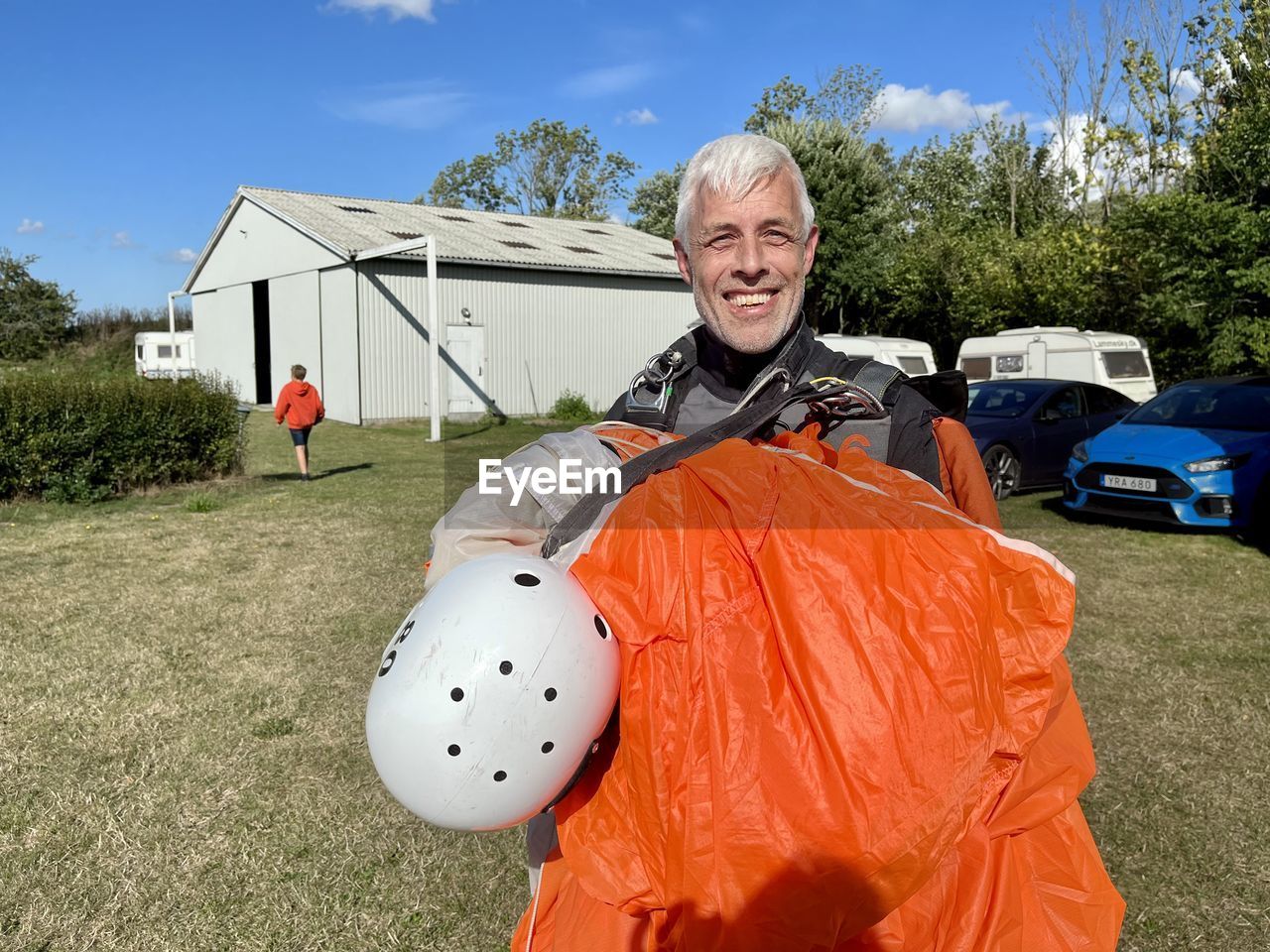 Hsppw skydiver after landing with orange  parachute.