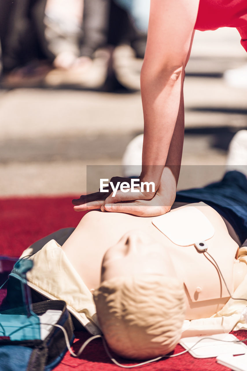 Cropped hands of woman demonstrating on cpr dummy