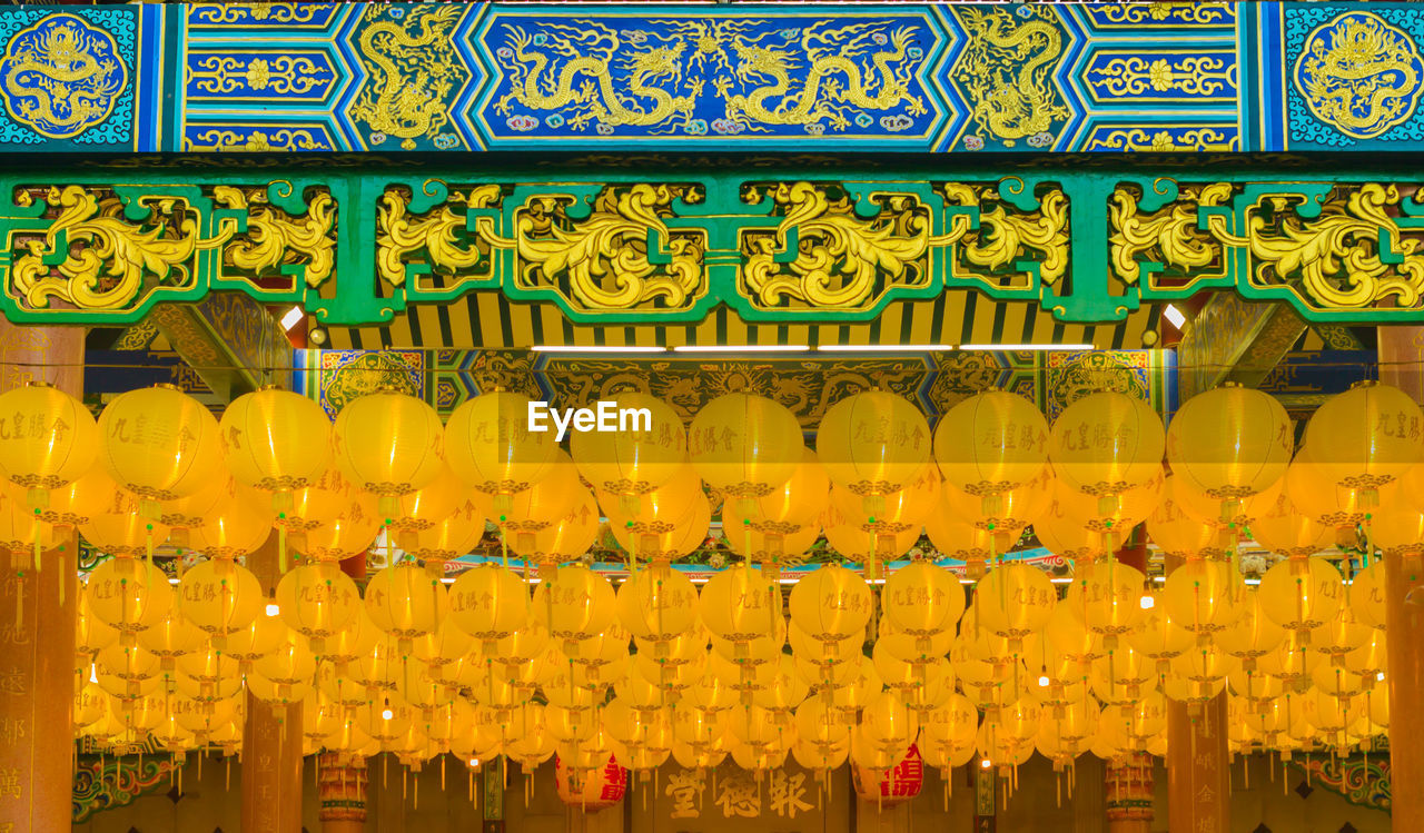 Low angle view of yellow lanterns hanging in temple