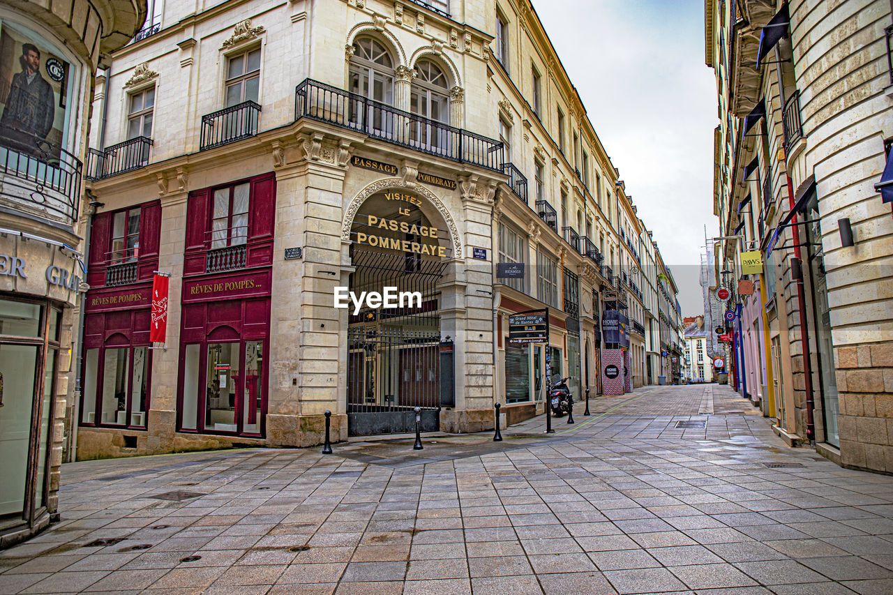 STREET AMIDST BUILDINGS AGAINST SKY