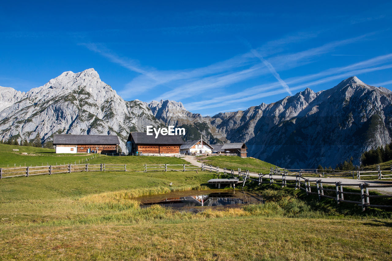 Built structure on field by mountain against sky