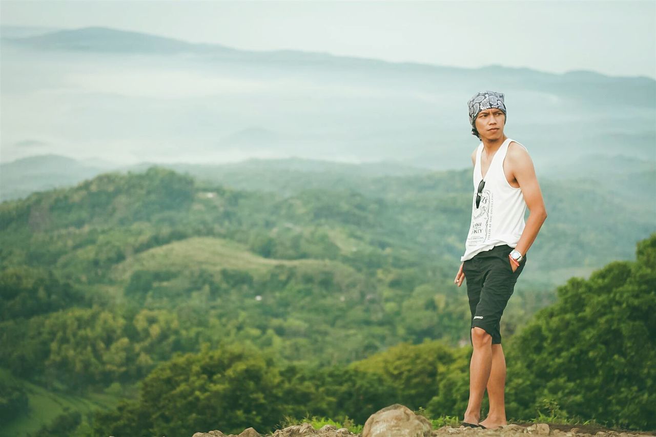 Full length of young man standing on cliff