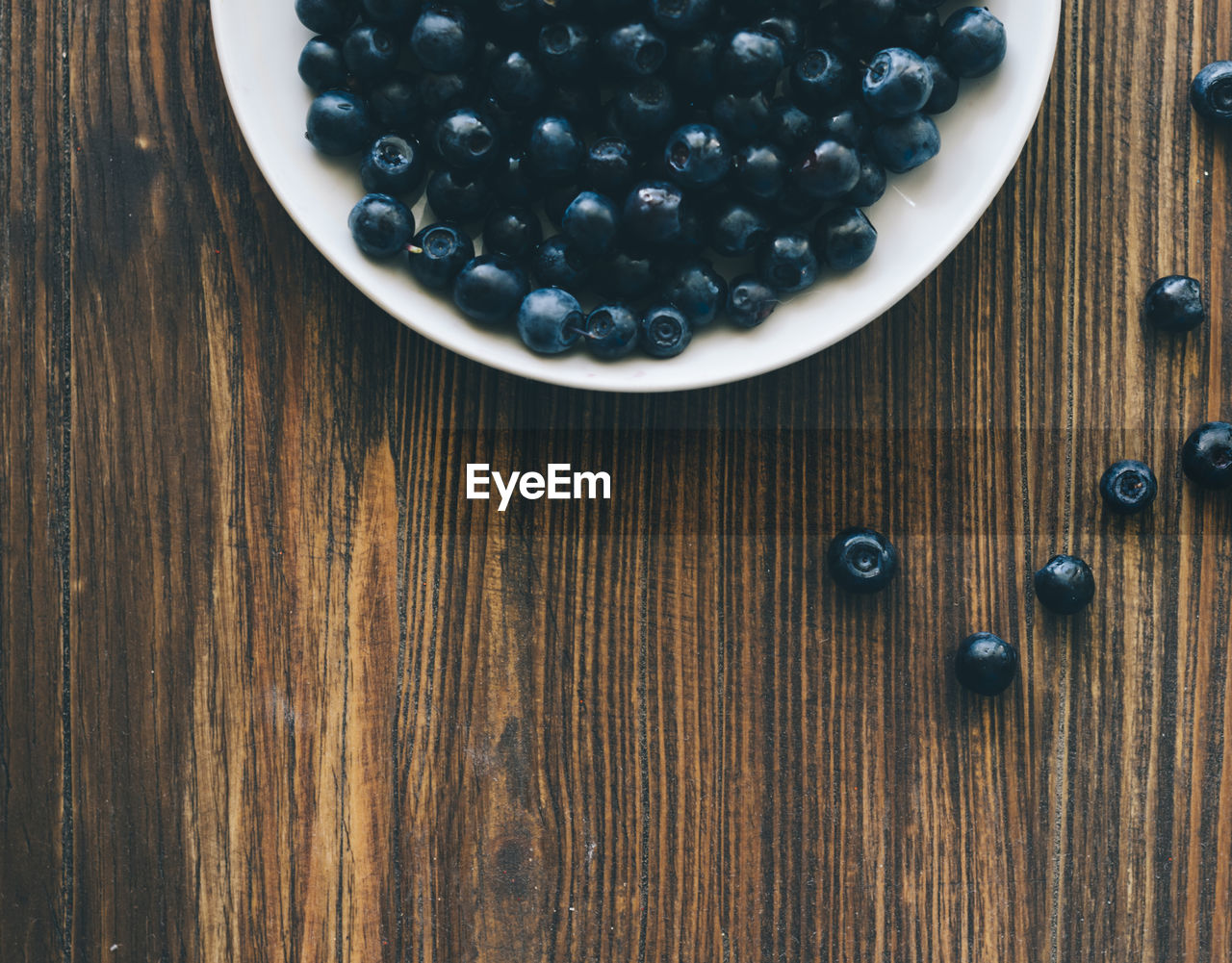 Directly above shot of blueberries in plate on wooden table