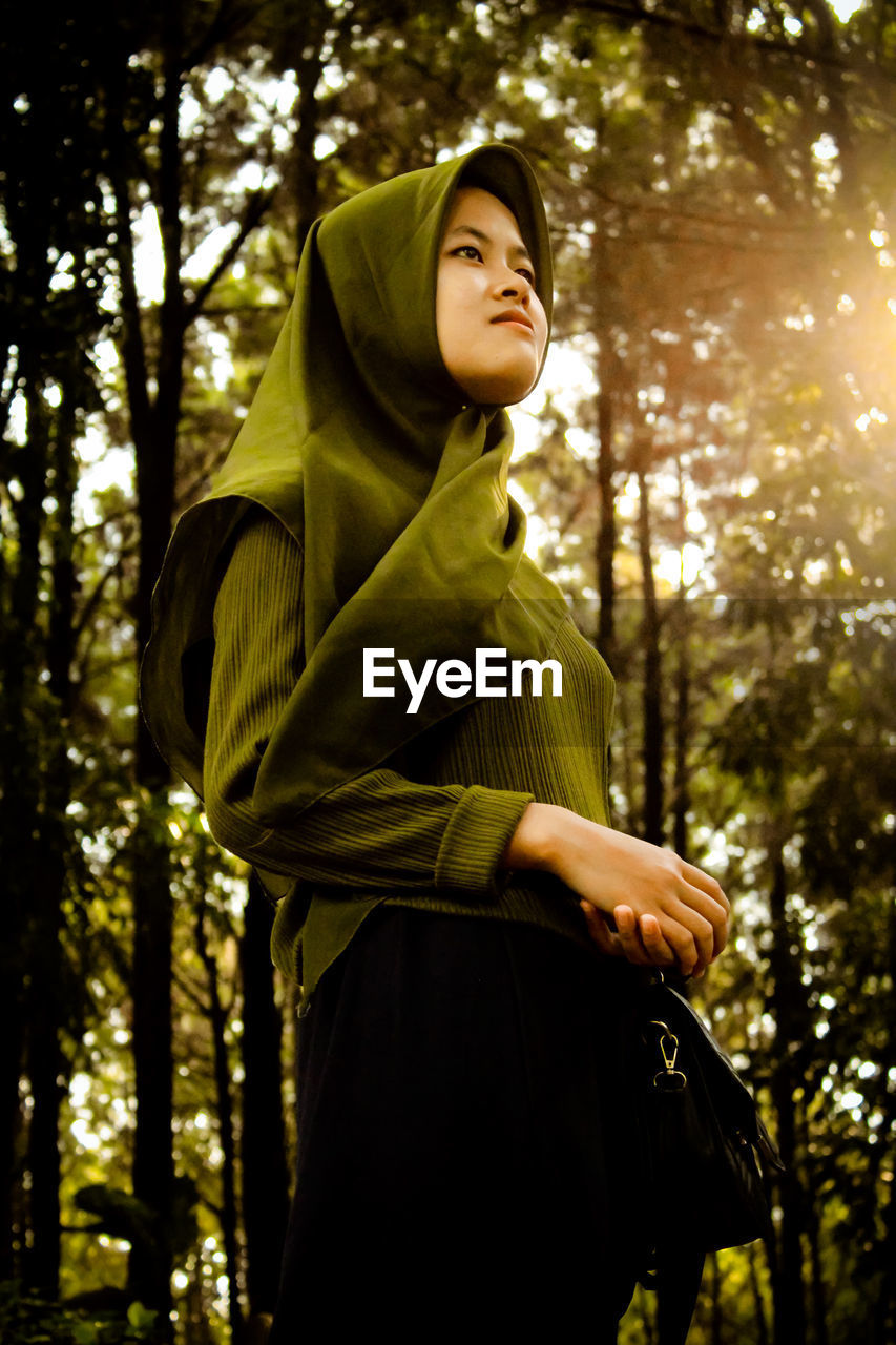 Young woman standing in forest