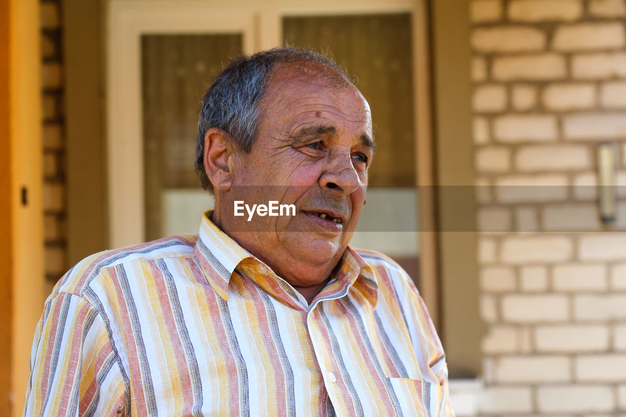 Portrait of a senior man outdoors. 70s years old latin or hispanic man standing outside in summer