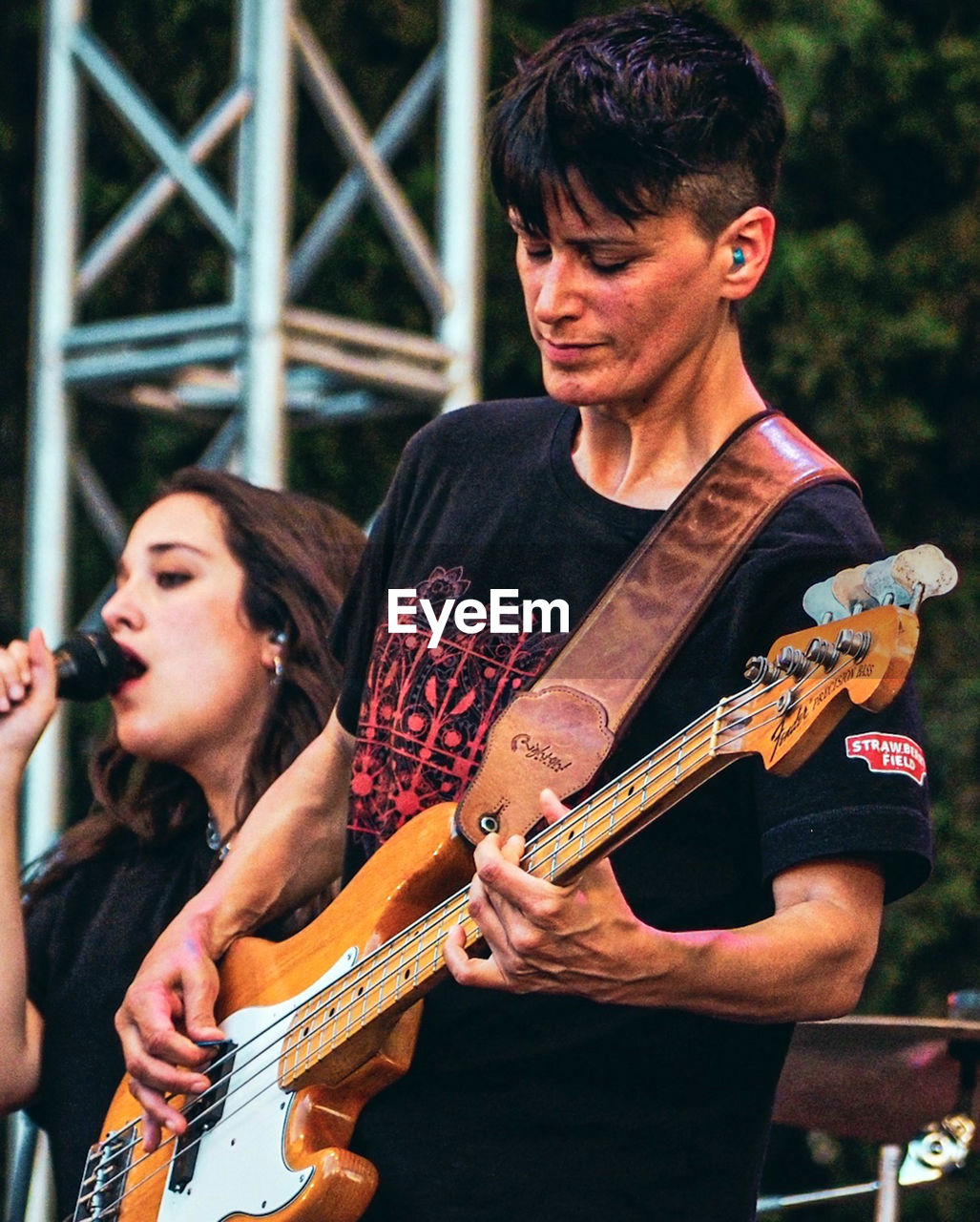 YOUNG MAN PLAYING GUITAR AT CAMERA