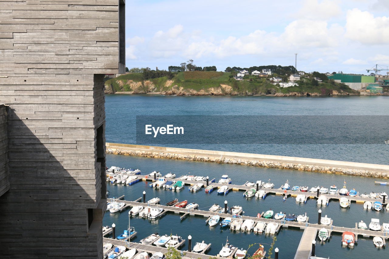 Scenic view of sea by buildings against sky