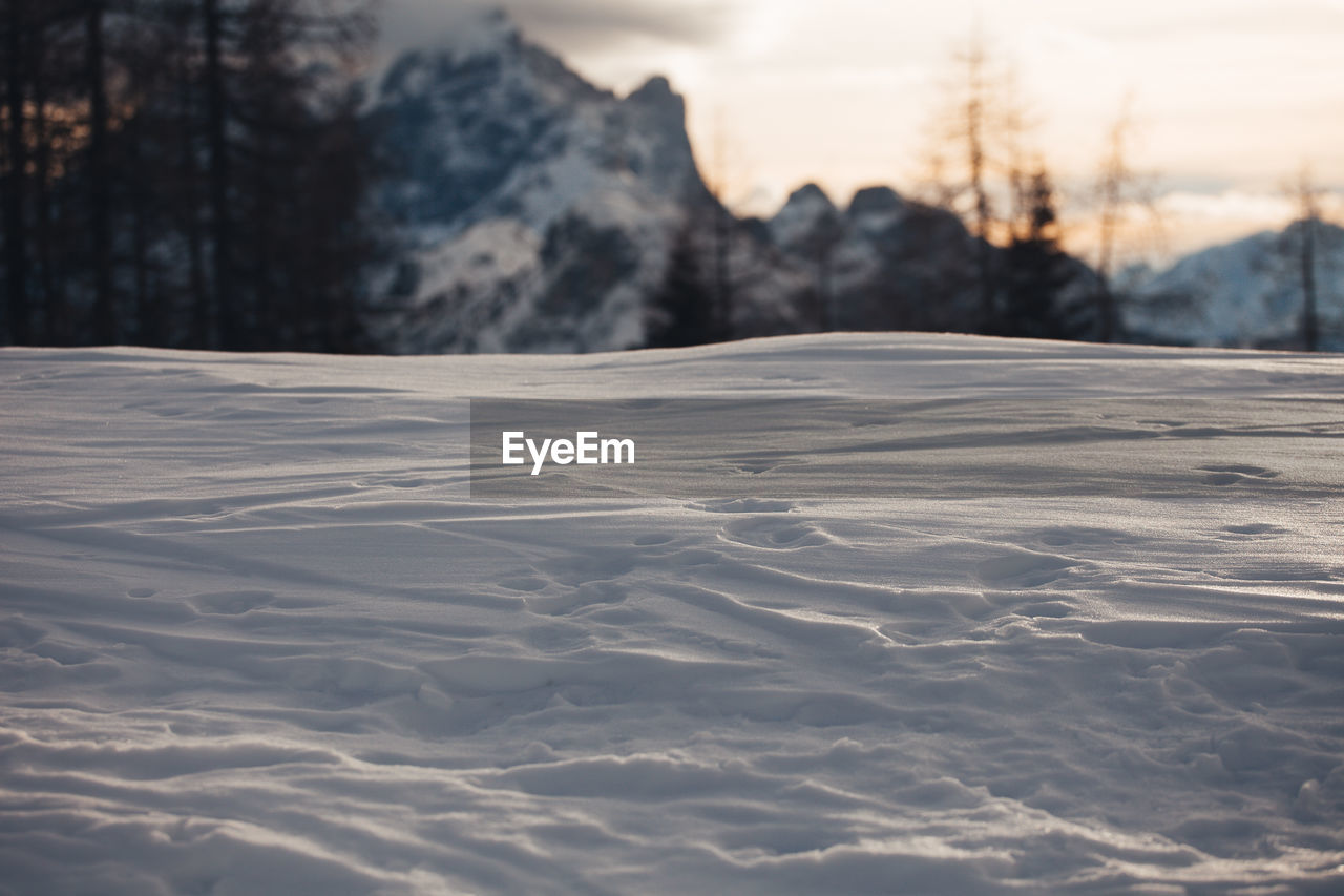 SURFACE LEVEL OF SNOW COVERED LAND AGAINST MOUNTAIN