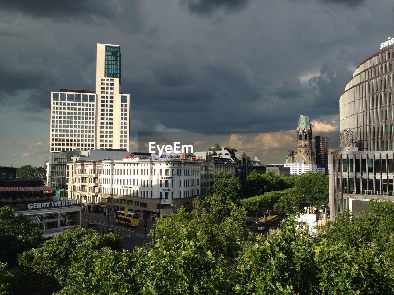 LOW ANGLE VIEW OF MODERN BUILDING AGAINST CLOUDY SKY