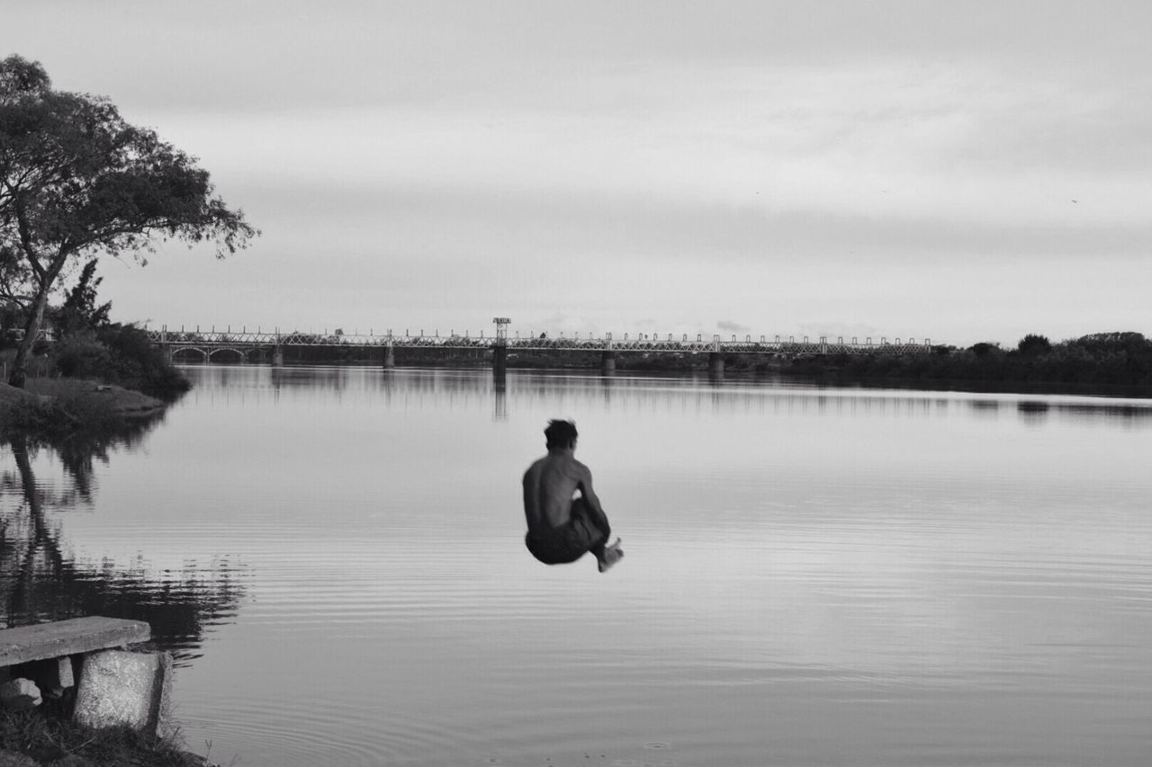 REAR VIEW OF MAN ON LAKE