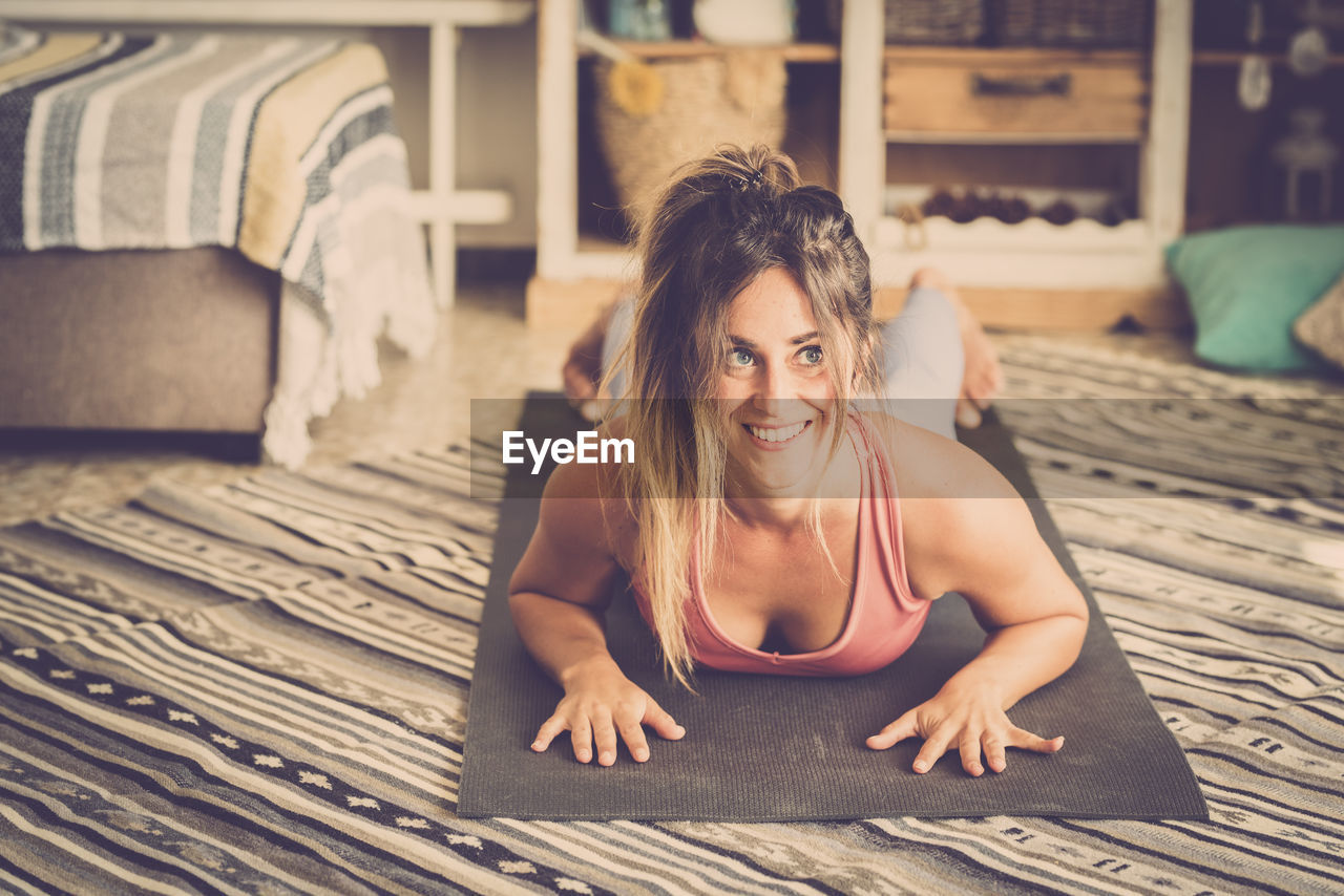 Woman looking away while lying down on floor