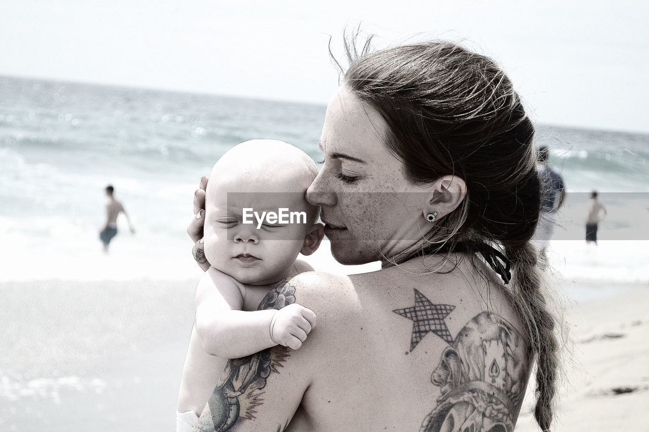 Mother and daughter standing at beach