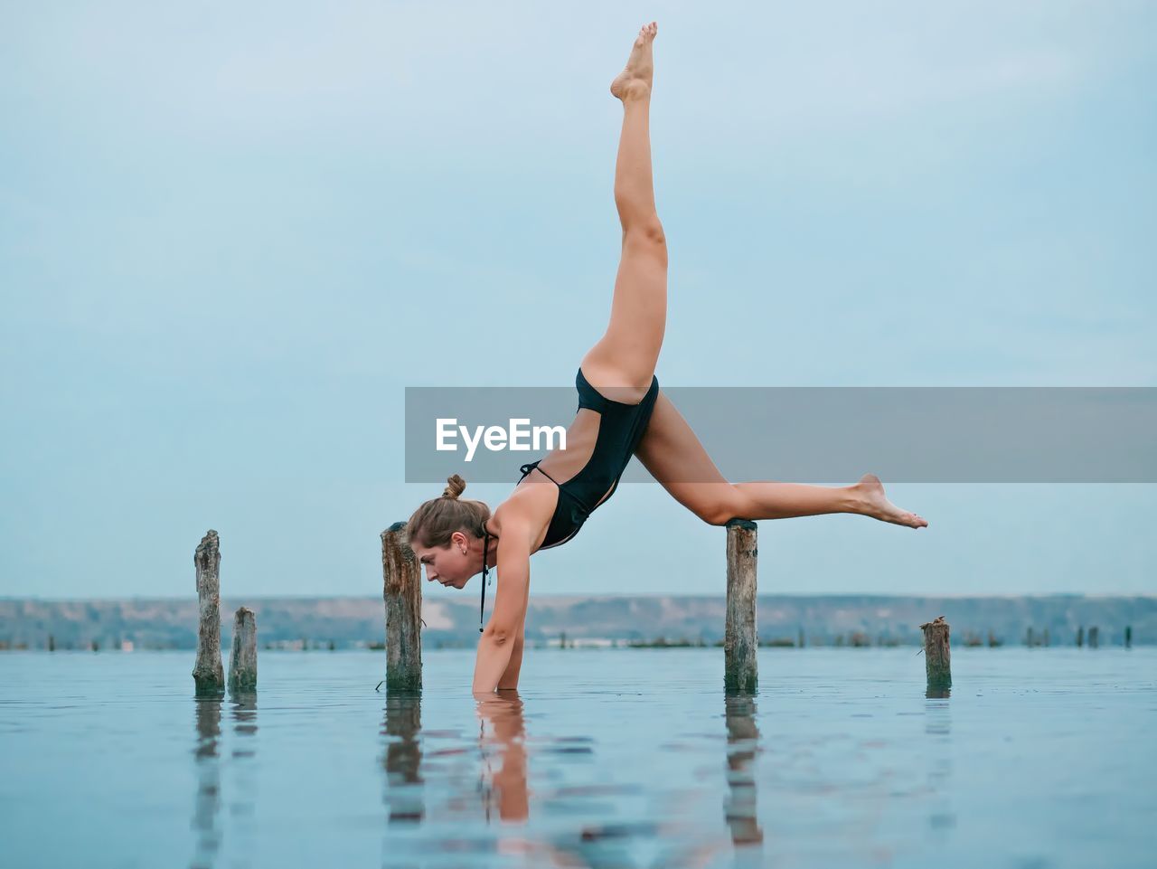 Full length of young woman in sea against sky