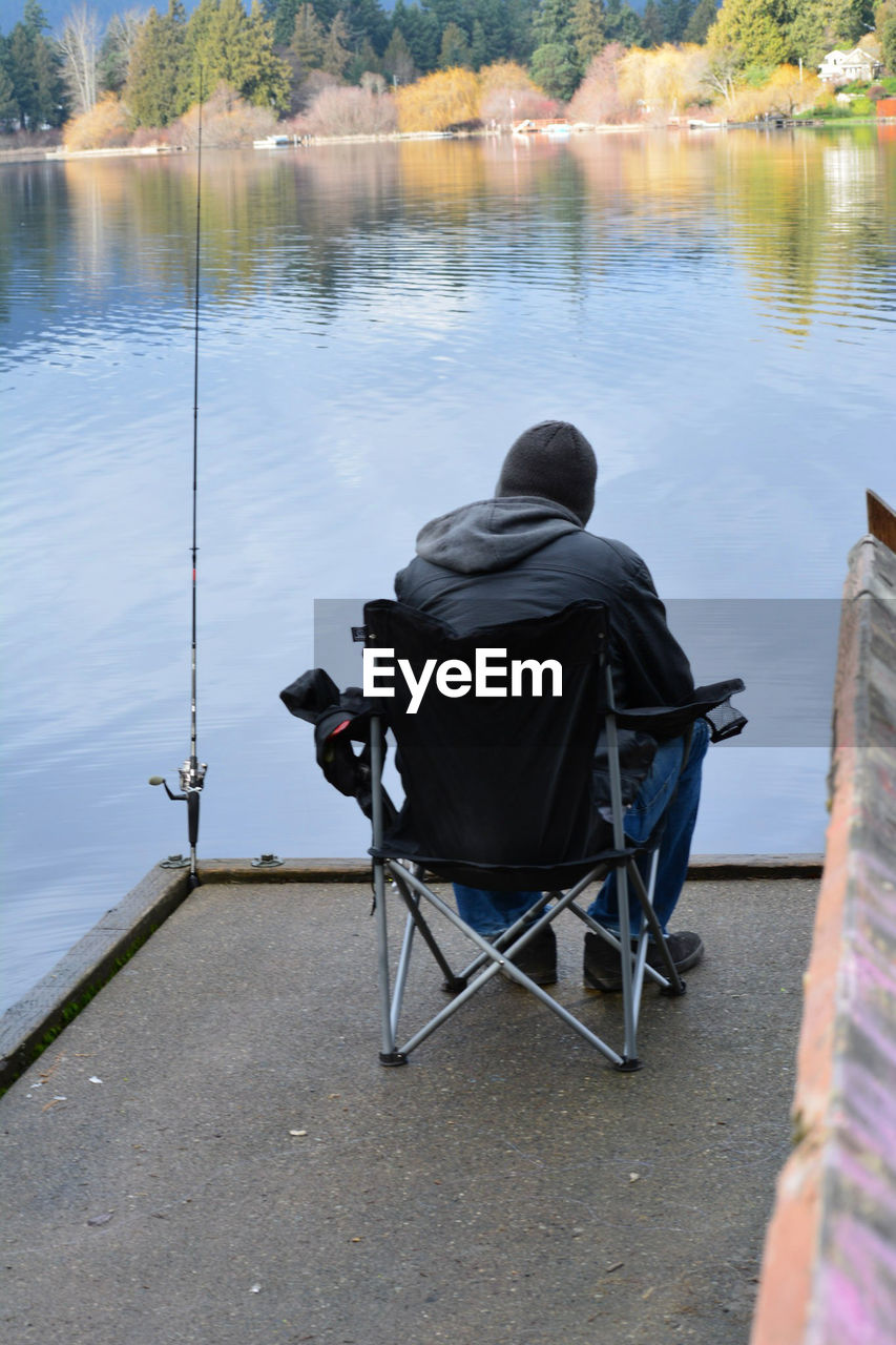 Rear view of man fishing at lake