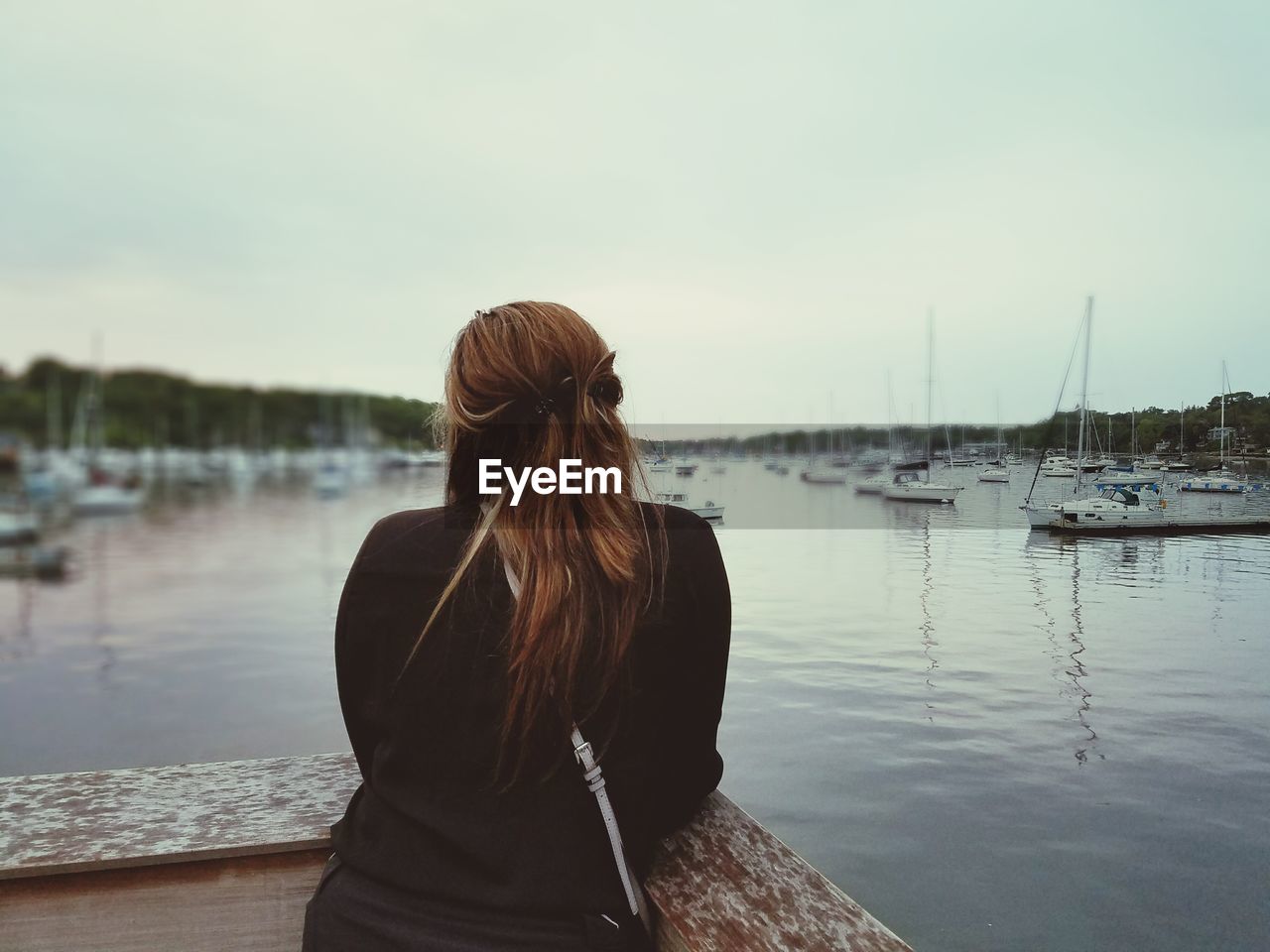 Rear view of woman overlooking calm lake