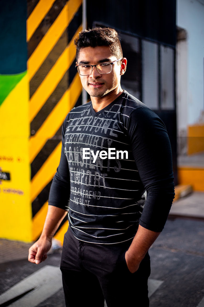 Portrait of young man standing on road