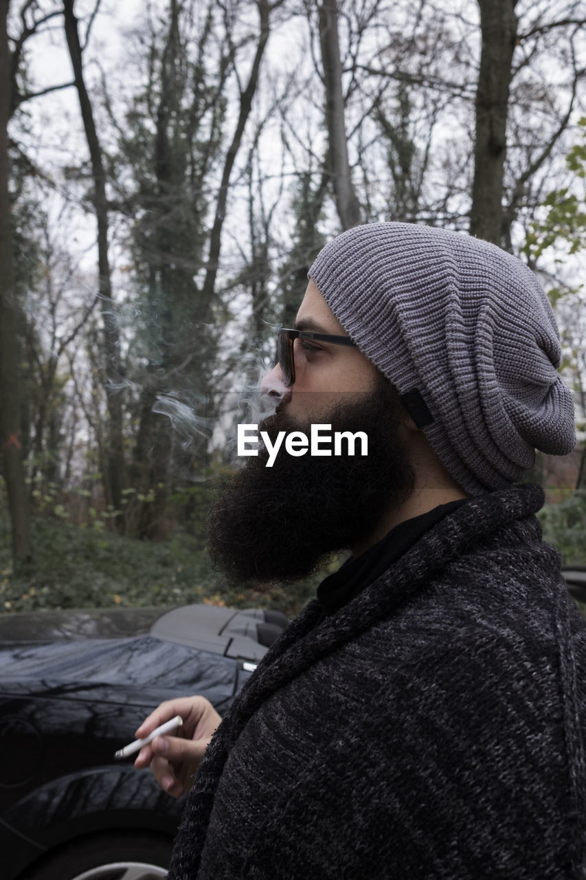 SIDE VIEW OF YOUNG MAN IN HAT