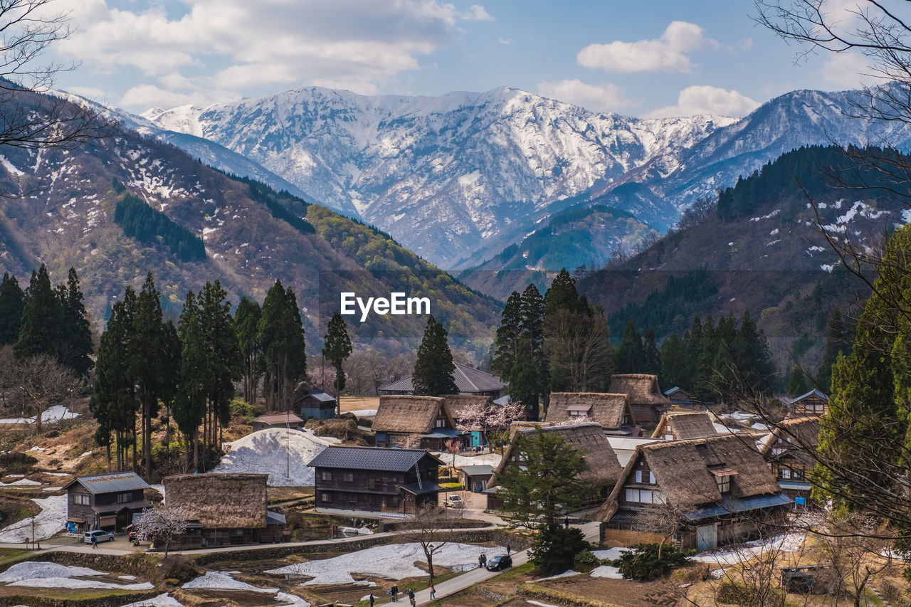 HIGH ANGLE VIEW OF TOWNSCAPE AND SNOWCAPPED MOUNTAINS