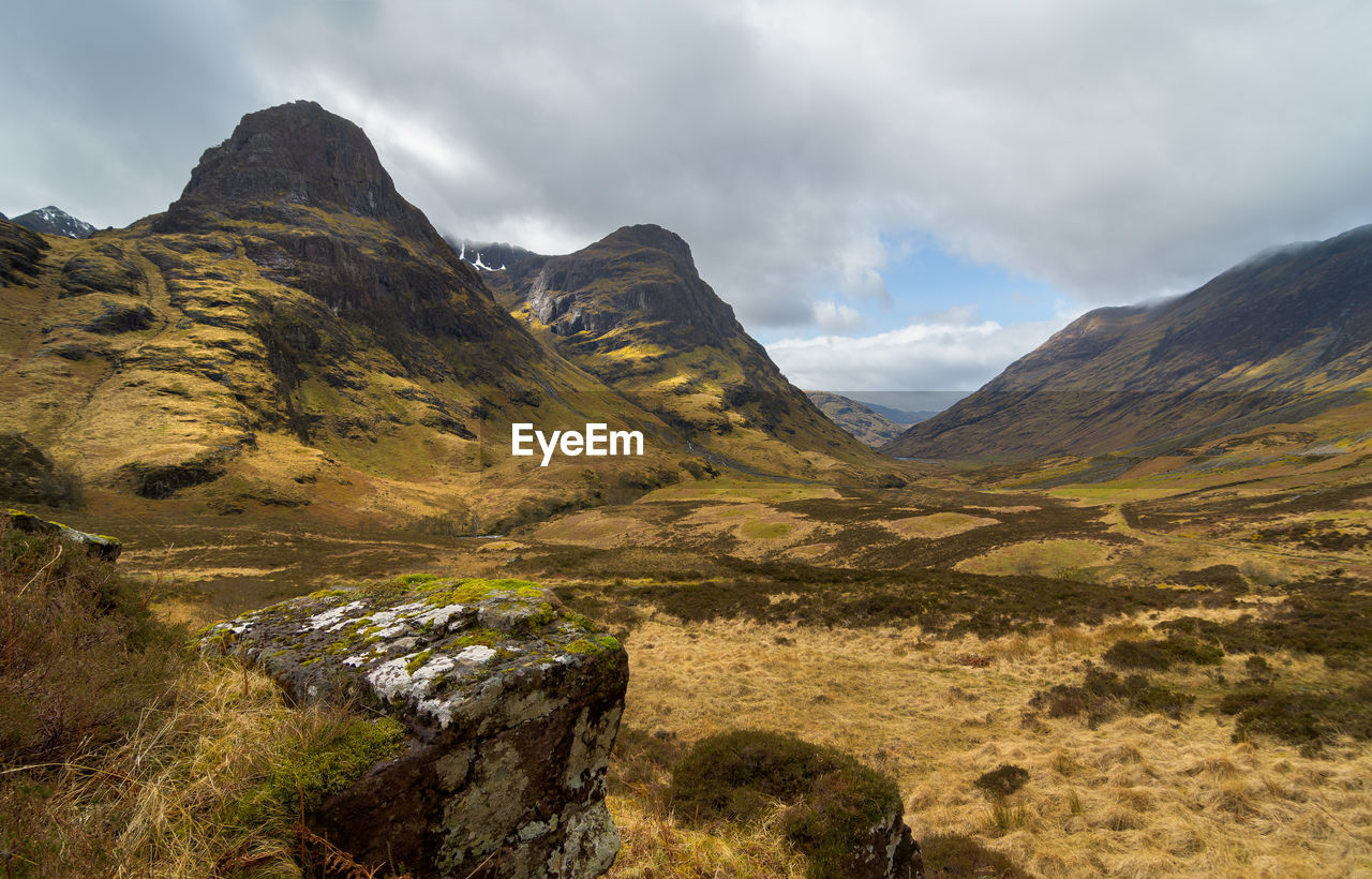 Scenic view of mountains against cloudy sky