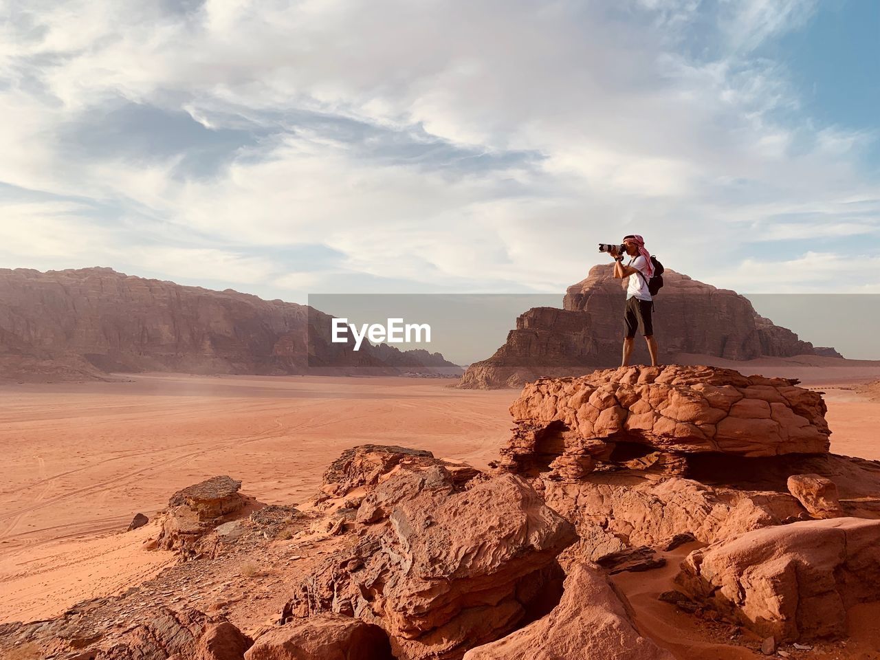 Full length of man photographing while standing on rock