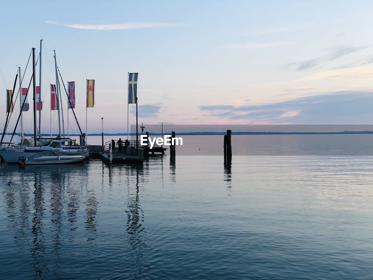 Sailboats in sea against sky during sunset