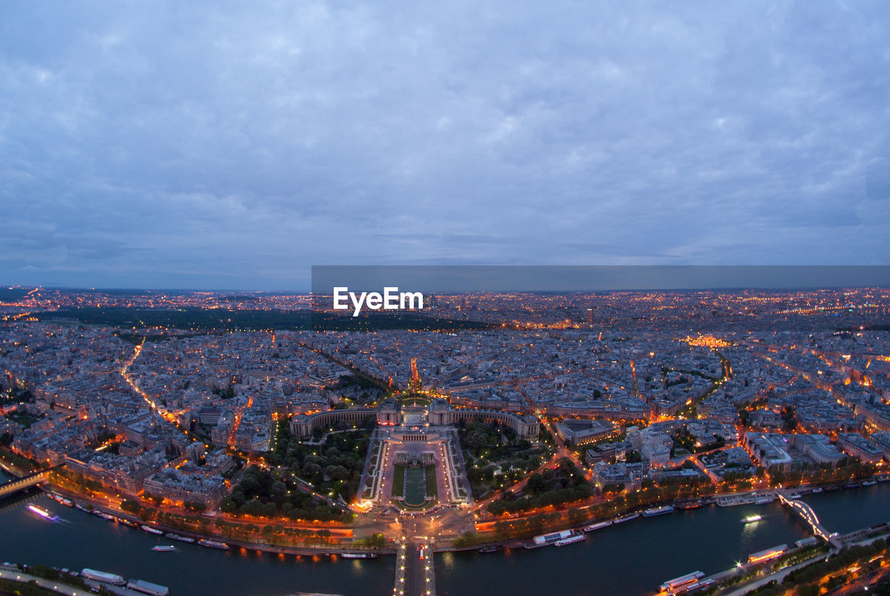 AERIAL VIEW OF ILLUMINATED CITY AGAINST SKY