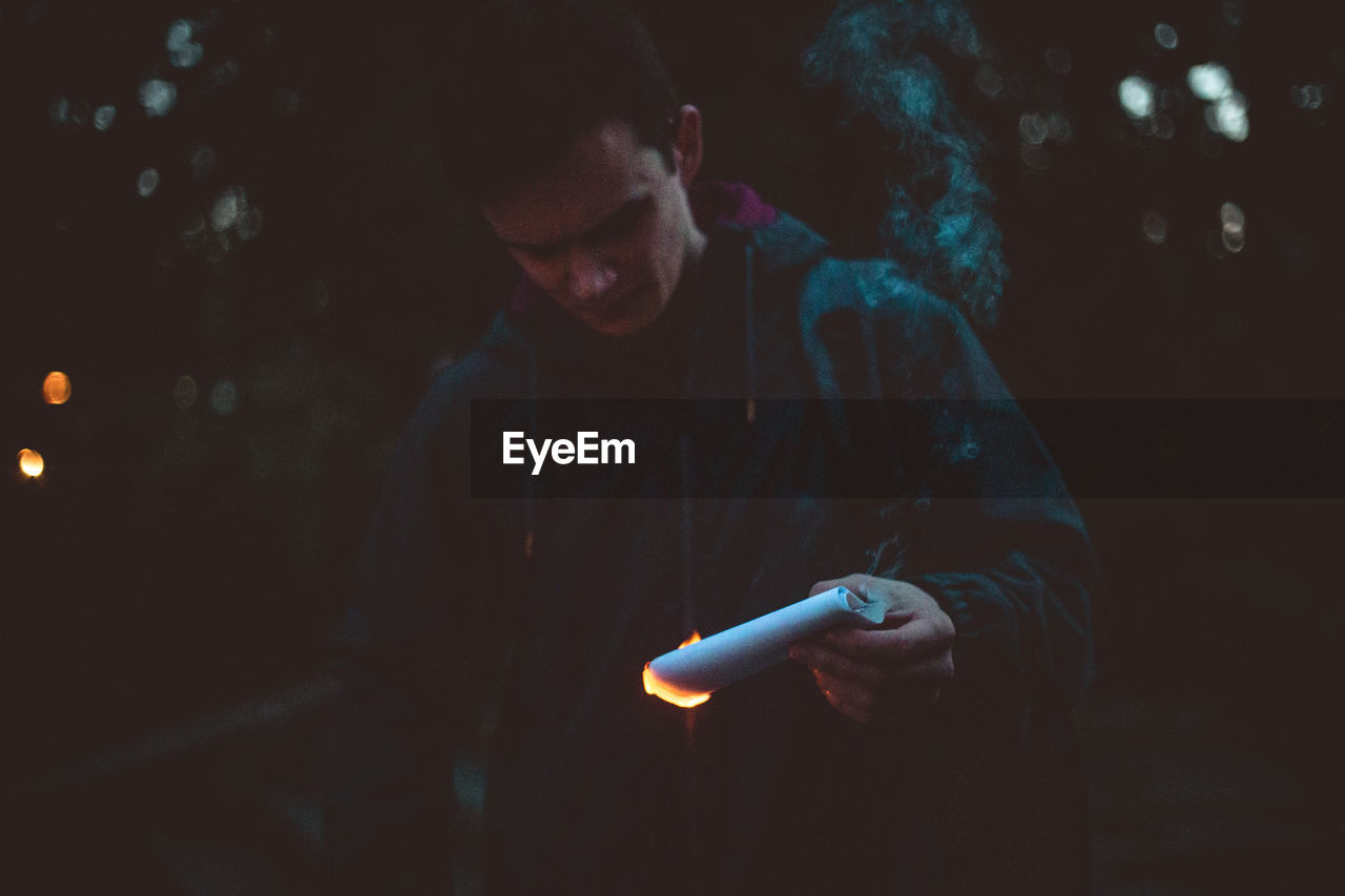 Guy holding burning paper