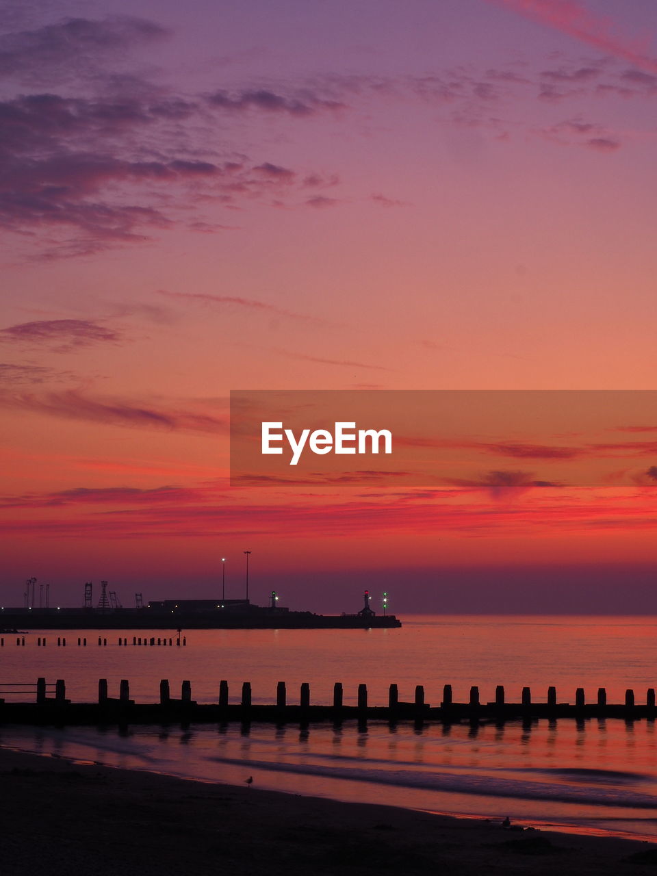 PIER OVER SEA AGAINST ROMANTIC SKY