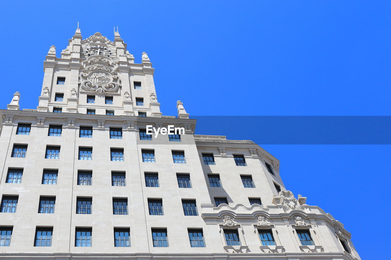 LOW ANGLE VIEW OF HISTORIC BUILDING AGAINST BLUE SKY