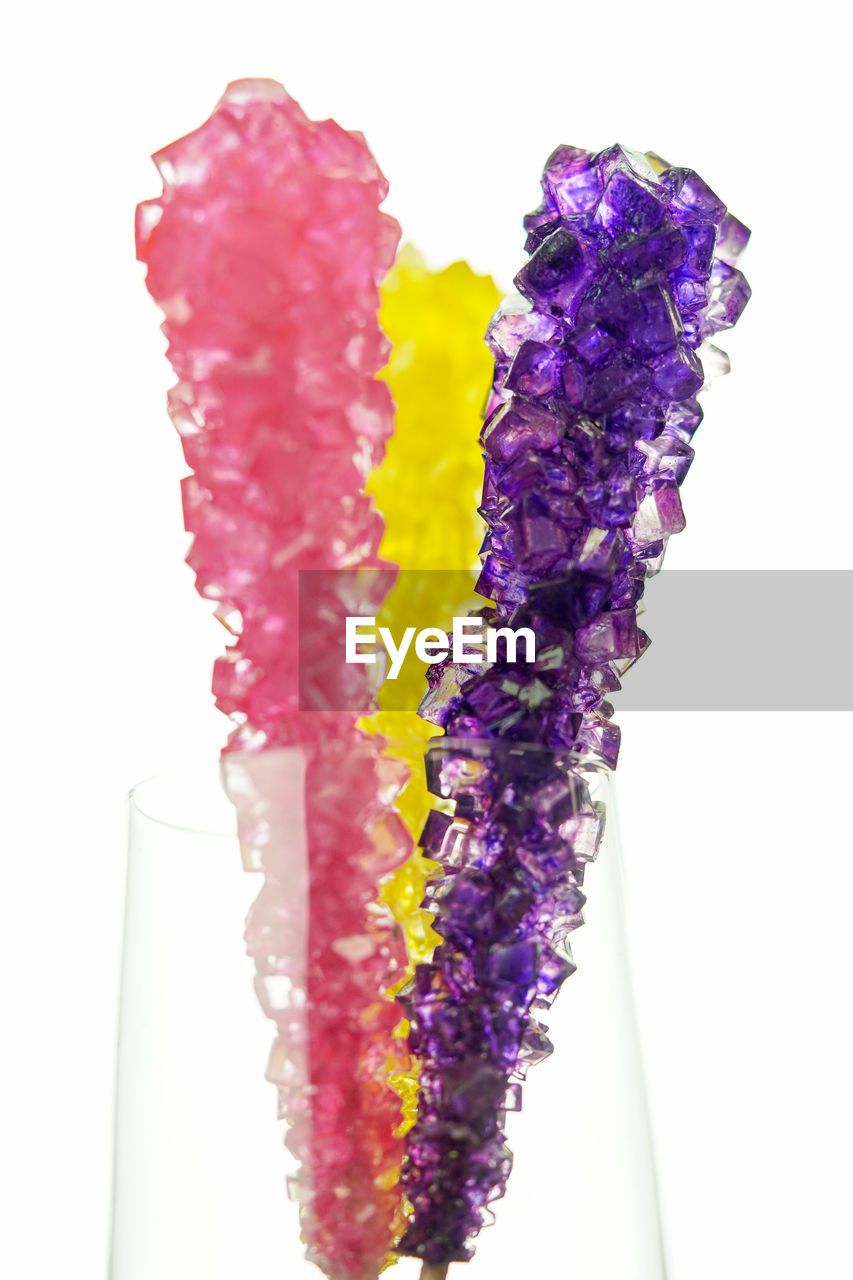 HIGH ANGLE VIEW OF PURPLE CANDIES AGAINST WHITE BACKGROUND