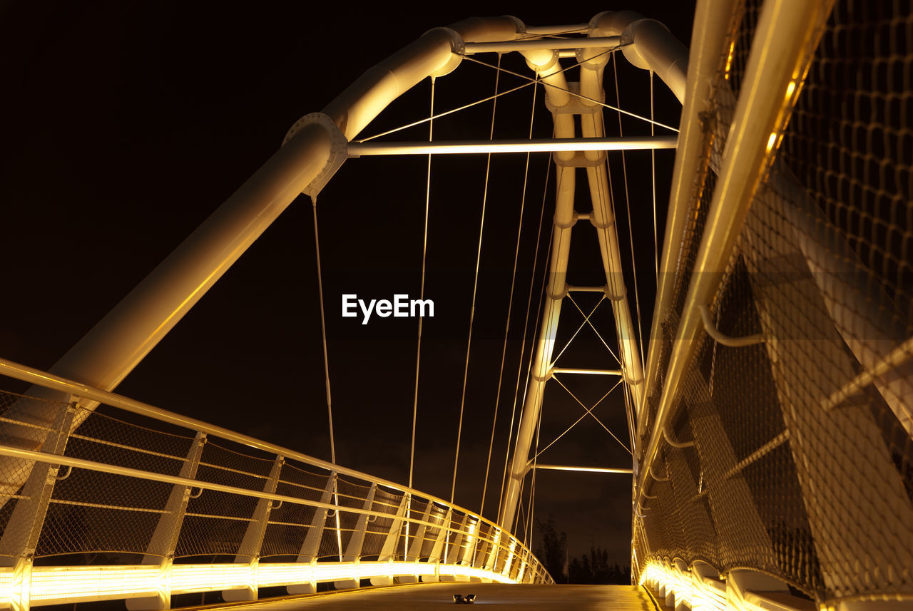 LOW ANGLE VIEW OF BRIDGE AT NIGHT