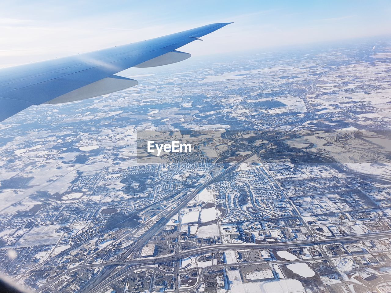 AERIAL VIEW OF AIRCRAFT WING OVER LANDSCAPE