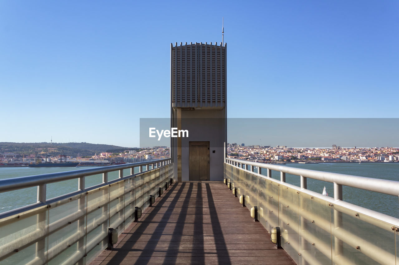 View of bridge and buildings against clear blue sky