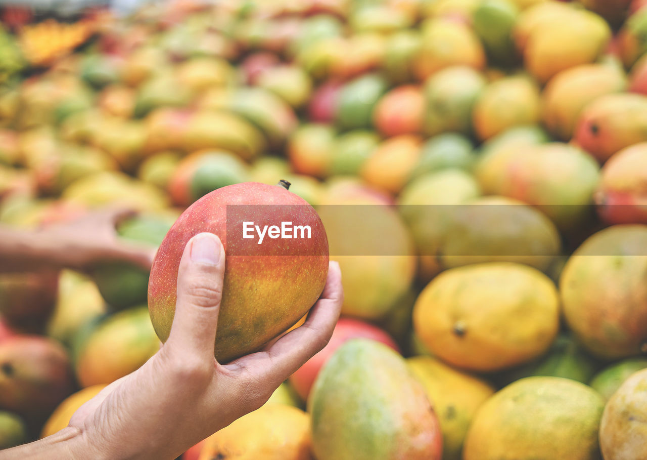 Close-up of hand holding apple at market