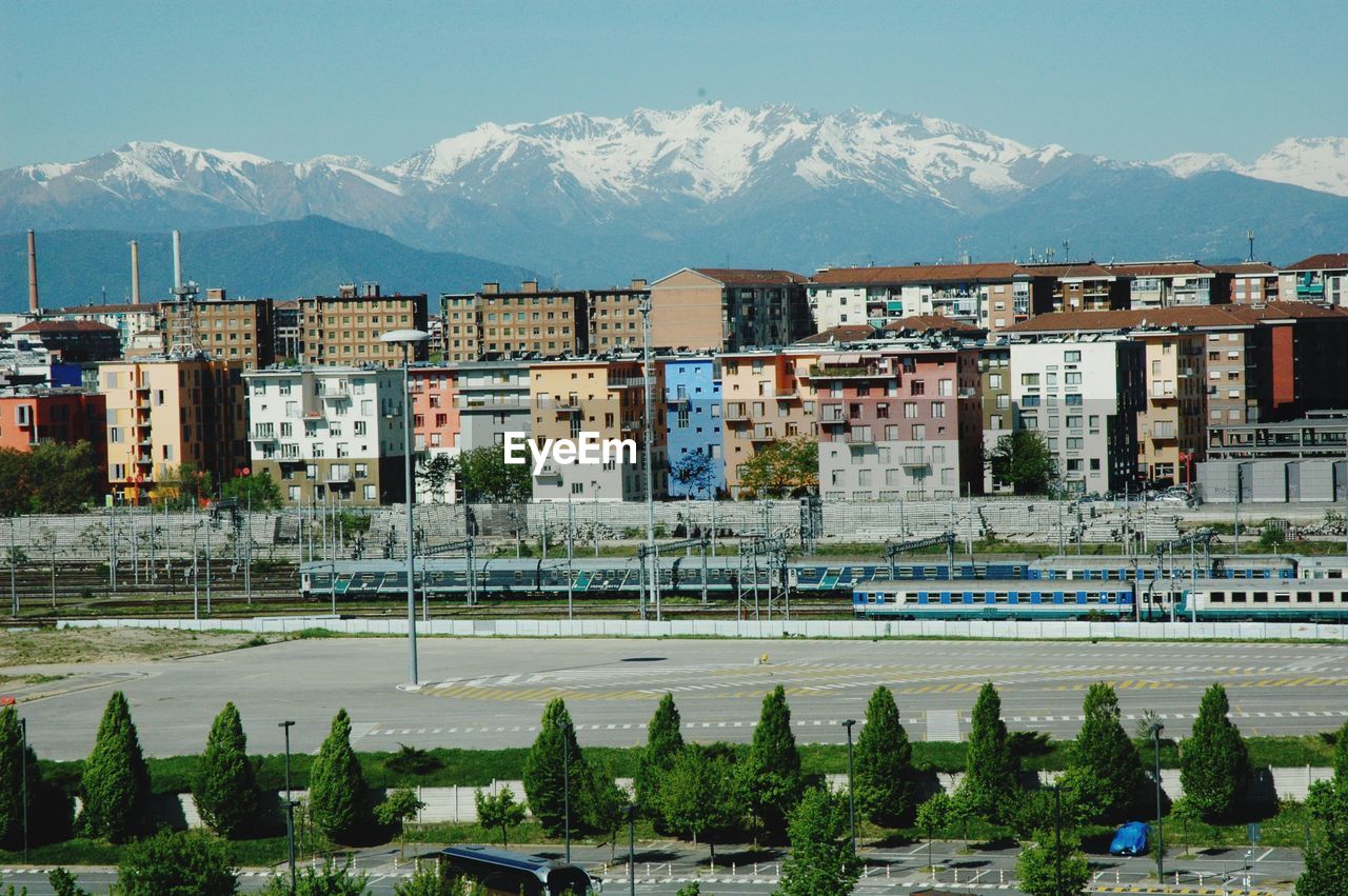 Buildings and railway area in city against sky