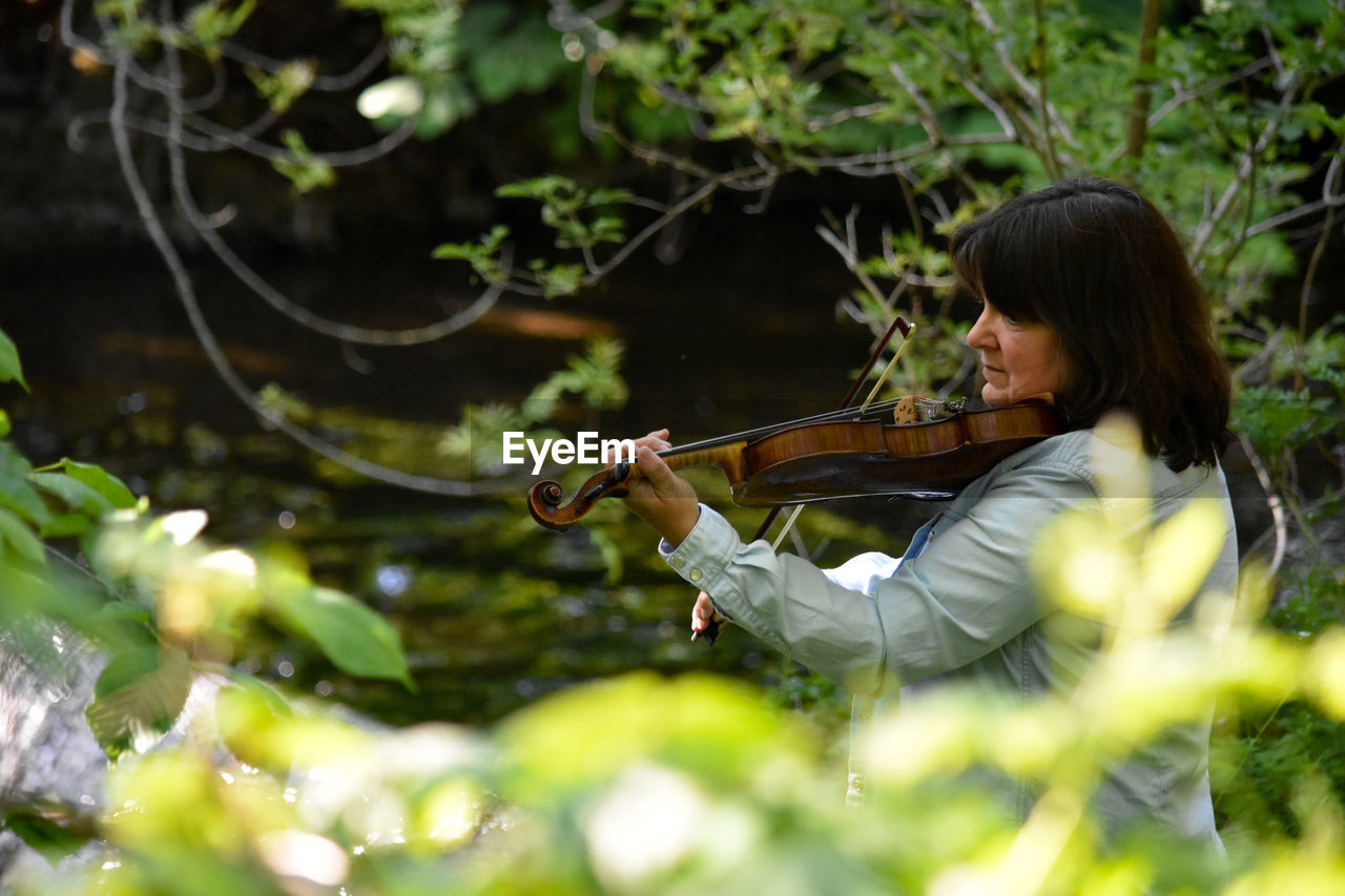 Side view of young woman playing outdoors