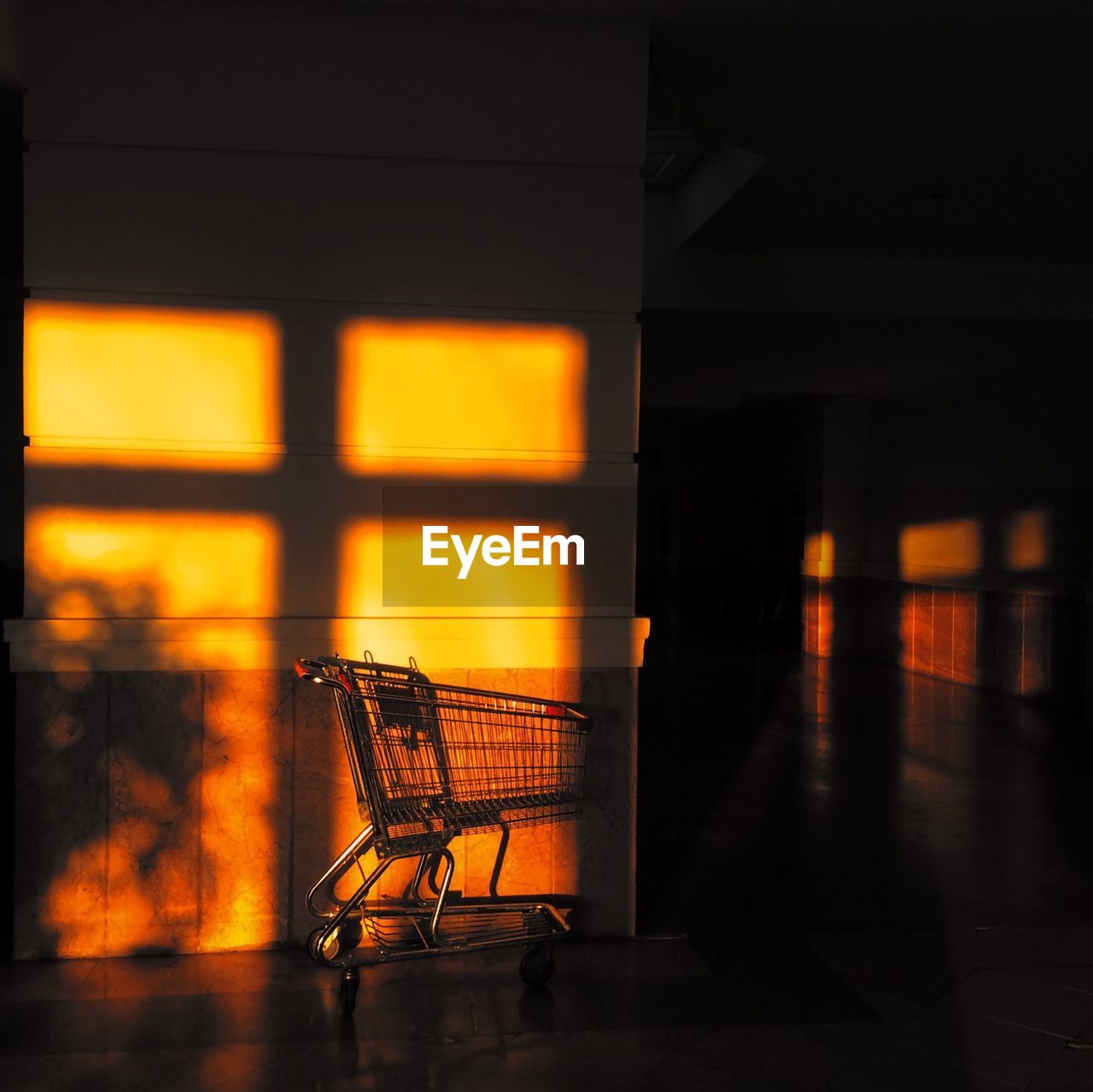 Sunlight falling on shopping cart in empty corridor