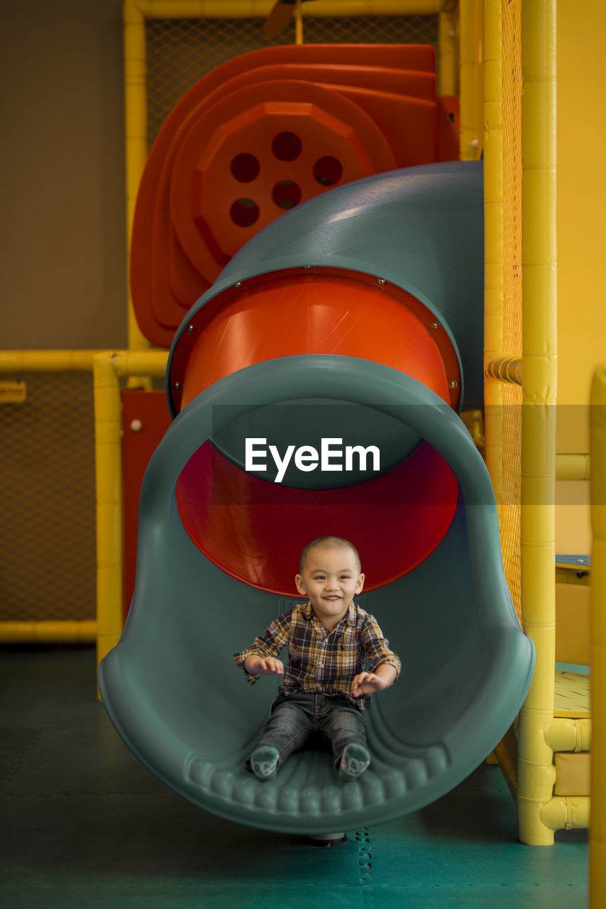 Full length of cute girl sitting at playground