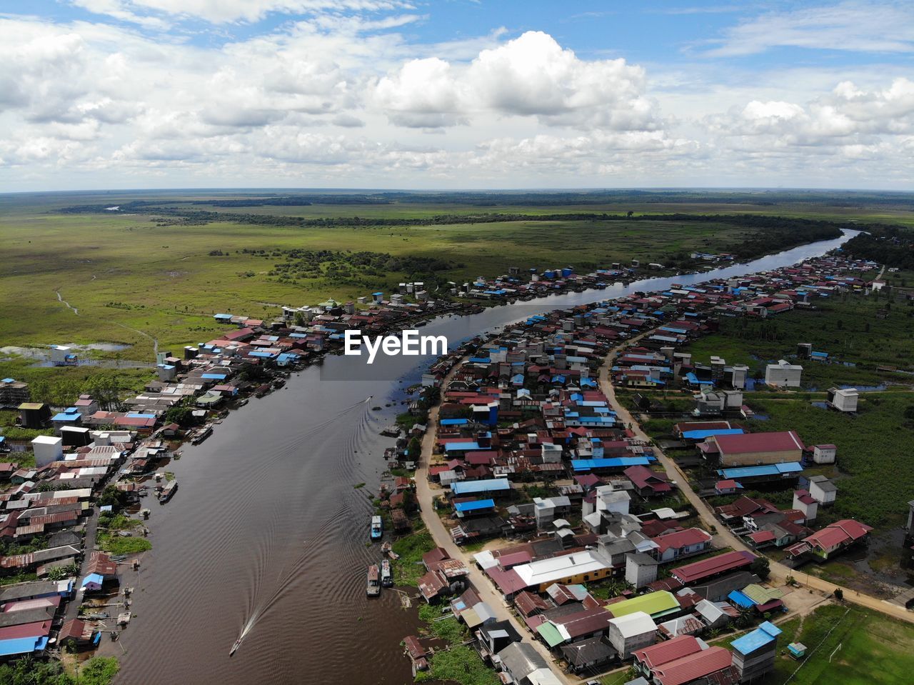 Aerial view of townscape by river against sky
