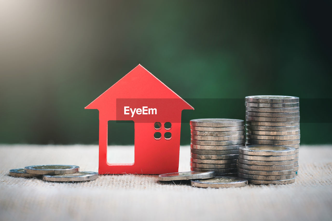 Model house and stack of coins. saving money for home purchase, mortgage and real estate investment.