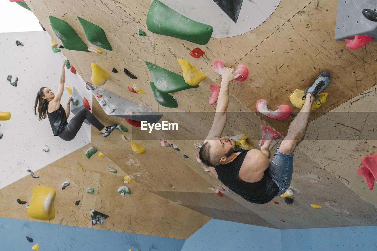 Man and woman bouldering in climbing gym