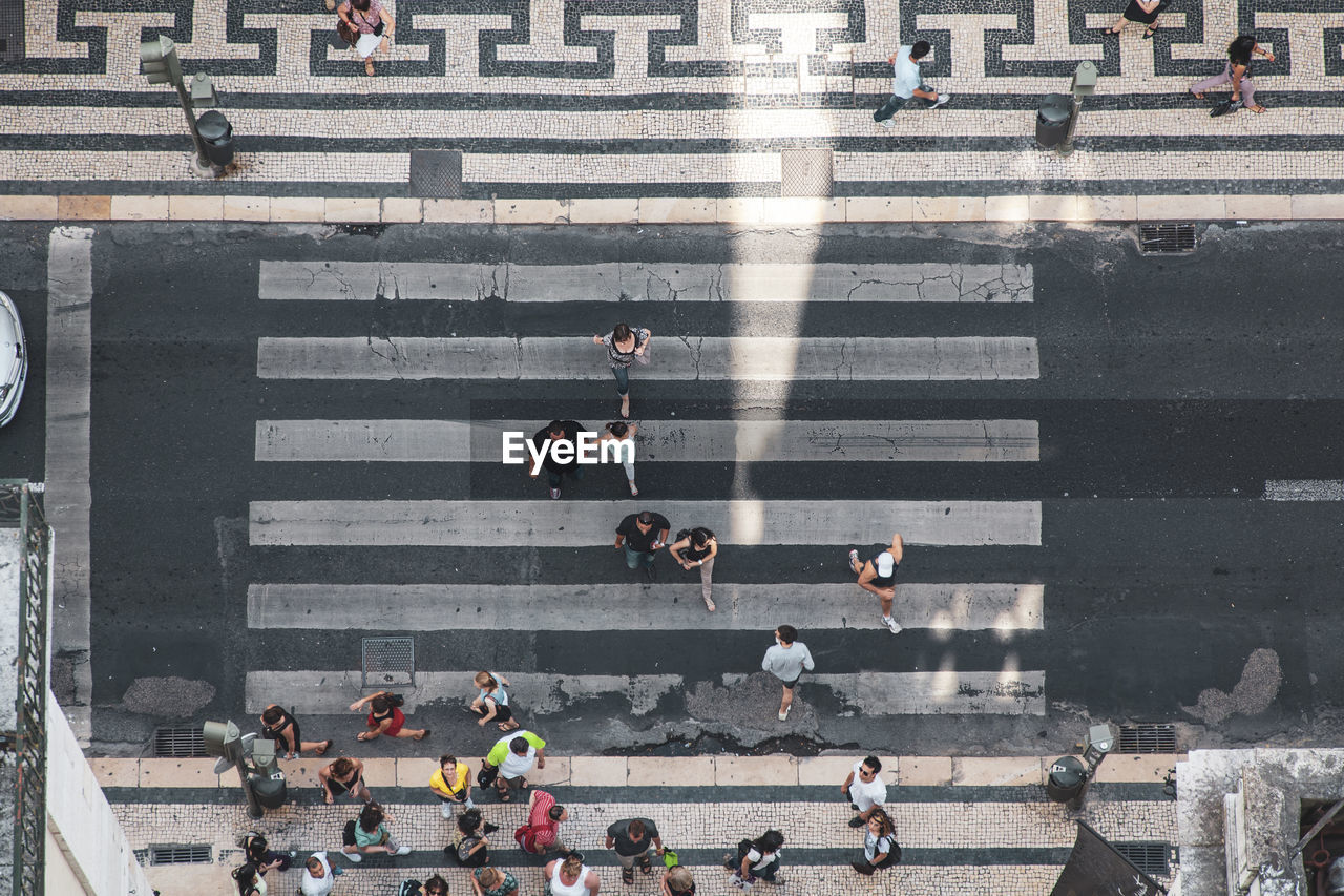 GROUP OF PEOPLE CROSSING ROAD IN CITY