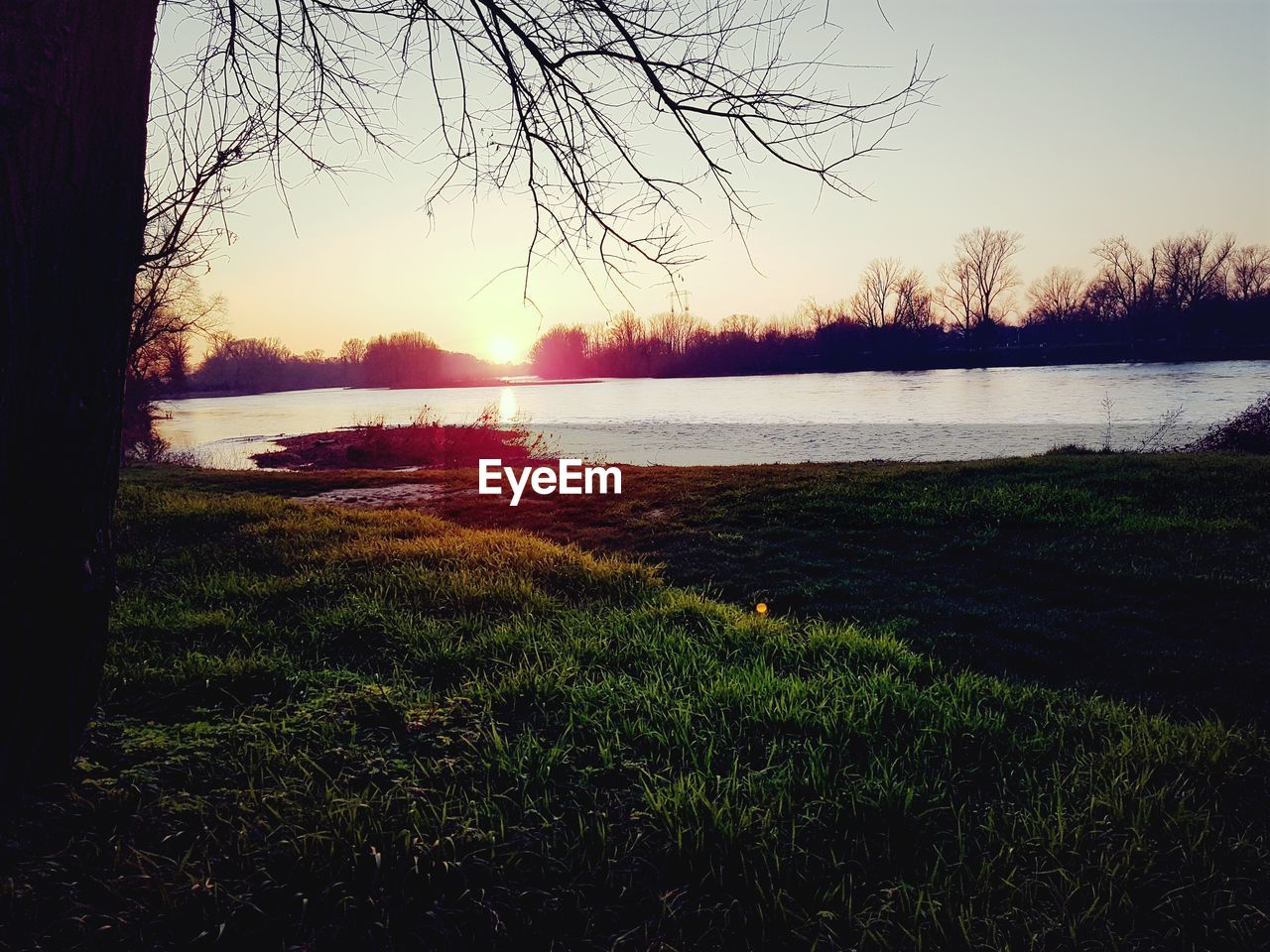 SCENIC VIEW OF LAKE AGAINST SKY AT SUNSET