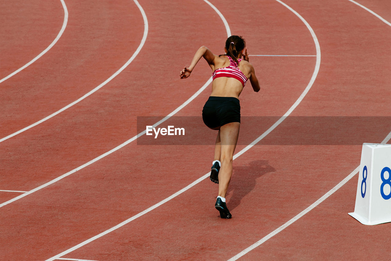 Girl runner athlete start of 400 meters race track and field competition